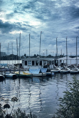 Fototapeta na wymiar Small sailing boats on the Alster in Hamburg dramatic sky pedalo morning