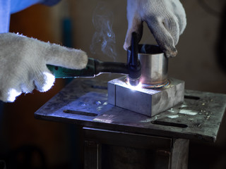 Men's hands with argon welding machine.  repair pipe stainless argon welding industrial construction