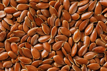 Background texture of seeds of dark brown flax.