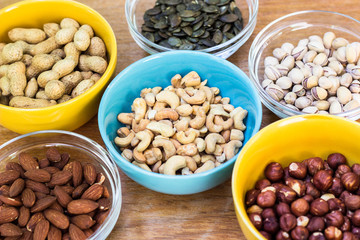 Assortment of mixed nuts on wood table background 