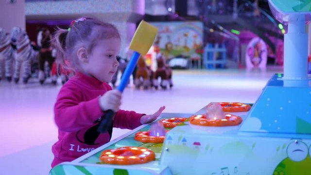 Little kid girl strikes a jumping frogs with hummer funny game