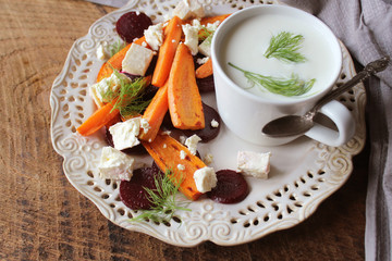 Healthy grilled beet, carrots salad with cheese feta, fennel and Greek yogurt in small glass bowls on the rustic wooden table, top view