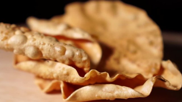 Indian Papadam fried savory treat, cooked and raw indoors isolated on wooden table