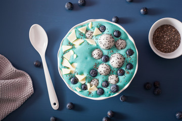 healthy blue spirulina smoothie bowl with blueberry, white chocolate, dragon fruit, chia seed