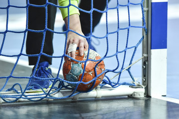 Hand of handball goalkeeper takes the ball from the goal. - obrazy, fototapety, plakaty