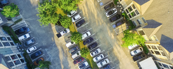 Panorama aerial view of apartment garage with full of covered parking, cars and green trees of multi-floor residential buildings in Houston, Texas, US. Urban infrastructure, transportation concept