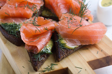 Homemade gravlax, smoked salmon with mustard sauce and dill  on toasted rye bread