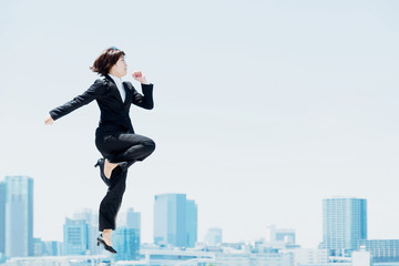 Fototapeta na wymiar 勢い良くジャンプする女性（ビジネスイメージ）