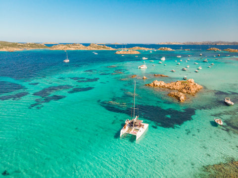 Fototapeta Drone aerial view of catamaran sailing boat in Maddalena Archipelago, Sardinia, Italy. Maddalena Archipelago is composed of Razzoli, Santa Maria and Budelli islands.