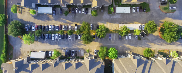 Panorama aerial view of apartment garage with full of covered parking, cars and green trees of...