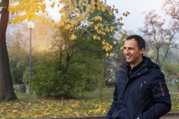 Handsome man walking in the autumn park