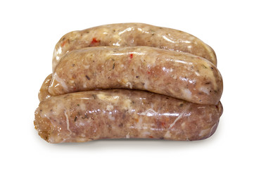 Raw sausages with herbs and hot red pepper on white isolated background