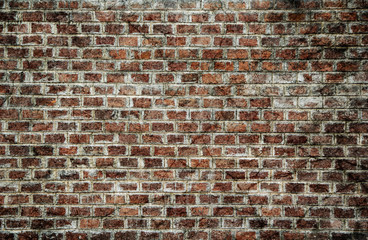 Background and Wallpaper or texture of dark discolored old brick wall ancient vintage retro style have damage and cracks.