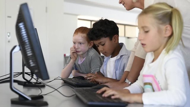 Kids in computer class with teacher