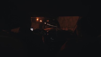 A family couple travels by car and goes through a long dark car tunnel. View from the back seat of the car