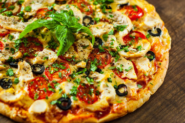 Pizza with Chicken meat, Mozzarella cheese, tomato, olive. Italian pizza on wooden background