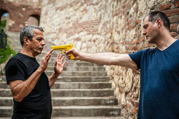 Robber with a gun attacks the victim. Gun point