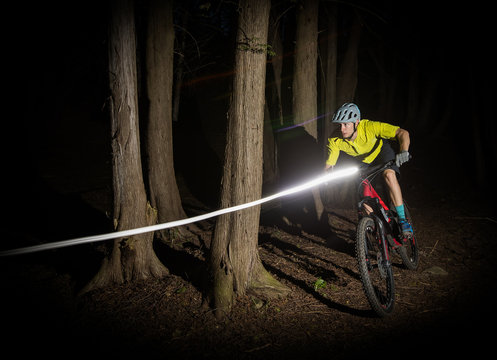 Man Riding A Mountain Bike At Night With Lights.