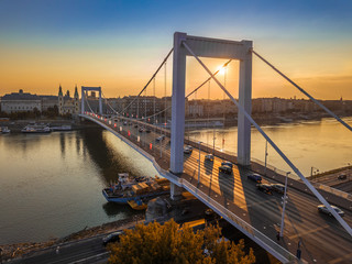 Budapest, Hungary - Beautiful Elisabeth Bridge (Erzsebet hid) at sunrise with golden and blue sky, heavy morning traffic and traditional yellow tram at background