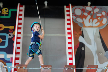 Young child crossing a bridge at the high rope course