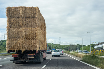 Truck transporting hay bales on a highway in the UK © pcruciatti