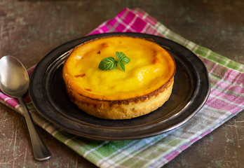 Fresh homemade creamy tart, on rustic dishware, napkin and background.