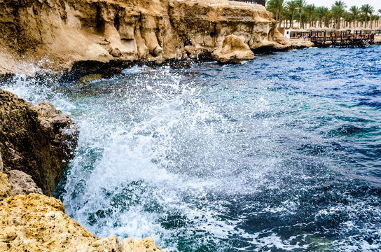 splashing waves of the surf crashing against the rocks on the beach of the red sea © Sofiia