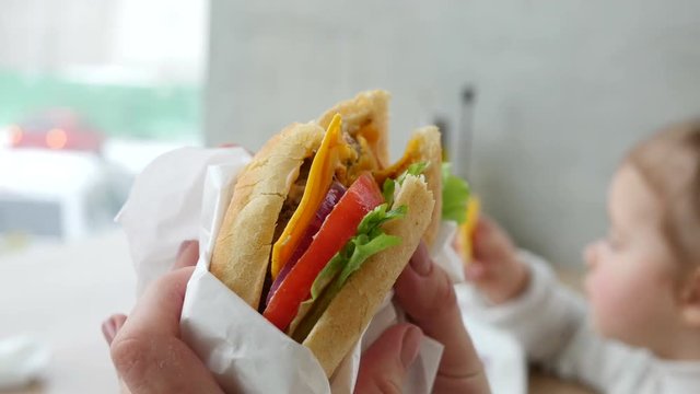 Eating fresh juicy sandwich at a fast food restaurant