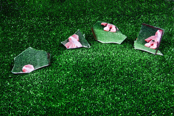 obiekt humanoid leżący na sztucznej zielonej trawie odbijający się w lustrach