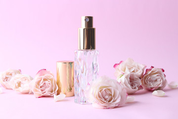 Obraz na płótnie Canvas perfume and flowers on a colored background.