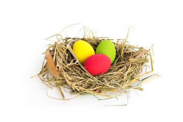 Colorful Easter eggs in Bird's nest From grass dry and straw or natural material isolated on white background.