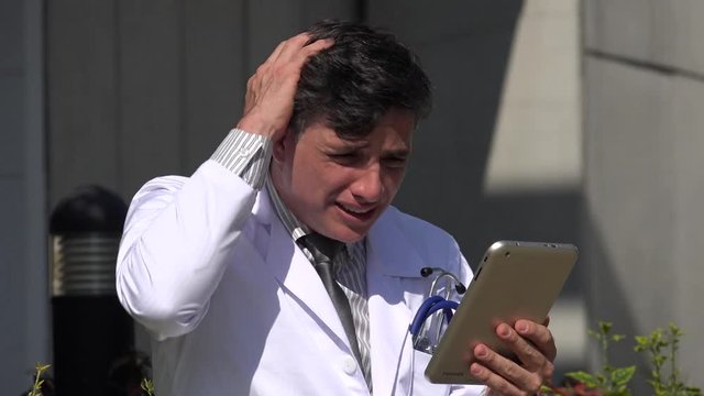 stressed hispanic male doctor using tablet