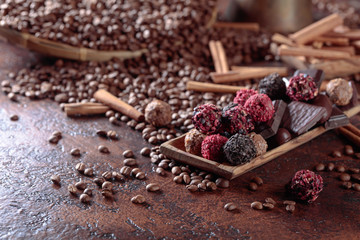 Various chocolates in wooden dish on a brown table.