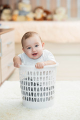 Little kid sitting in an office trash can, girl