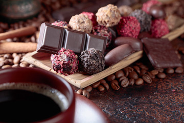 Various chocolates  and cup of black coffee.