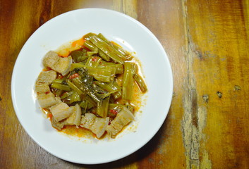 spicy fried morning glory with fat pork curry on plate