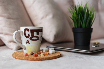 Laptop, pot of grass and a mug of coffee
