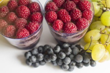 a hand with a beautiful manicure holds a cake in a Cup with berries and chocolate