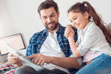 Father and little daughter at home sitting man showing daughter news cheerful