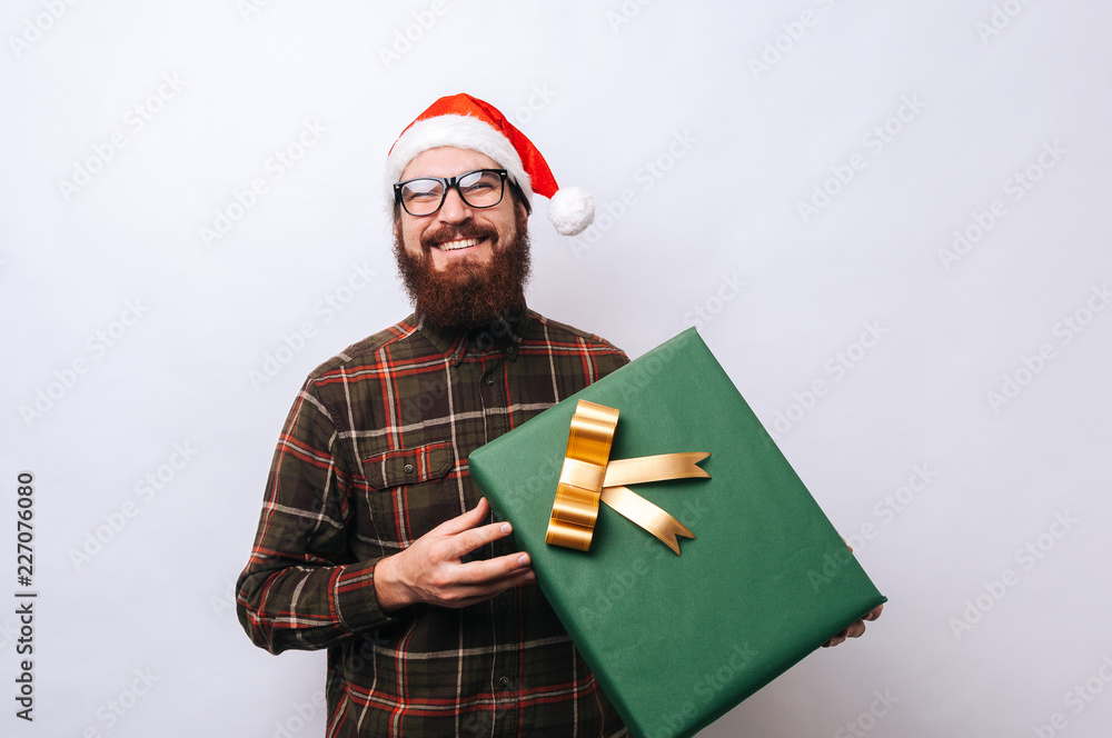 Wall mural cheerful young bearded man holding big gift