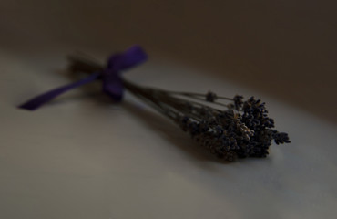 lavender bouquet whit purple ribbon lying on a white table