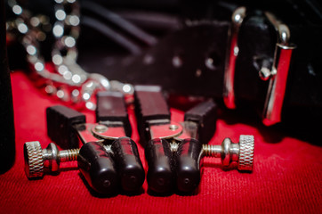 Naklejka premium bdsm accessory human collar and accessory nipple clasp with metal chain on a red background close-up