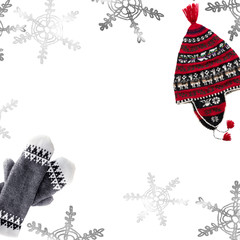 Hand-knitted mittens and hat on white background.