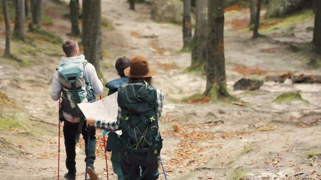 Fascinated, caucasian tourists learning the location as trekking in european mountains, having great time outdoors in early fall time