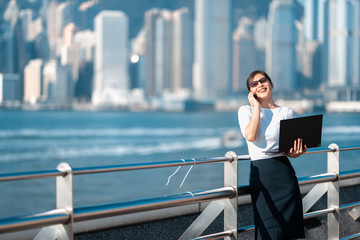 Business woman working on notebook outdoor in Hong Kong City