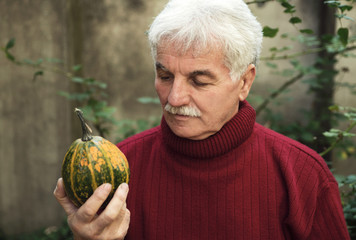 Senior man holding pumpkin