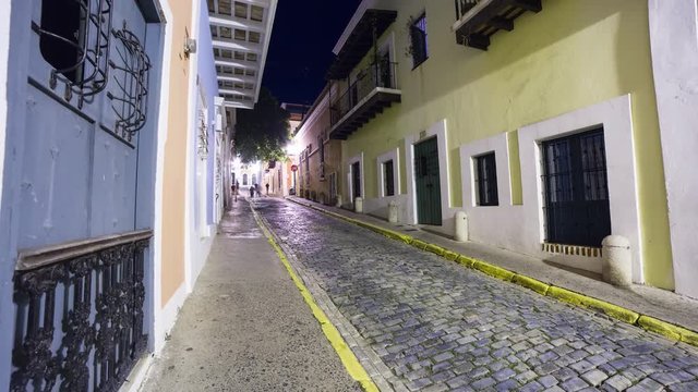Night time lapse hyperlapse of the colonial street of the old San Juan town, Puerto Rico. Blurred people.