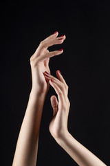 Closeup of beautiful woman hands with red manicure on the nails. Cream for palms, manicure and beauty treatment. Elegant and graceful arms with slender graceful fingers.