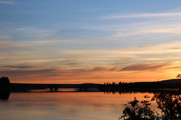 Fototapeta na wymiar Sunset in the North, midnight sun over the river in Rovaniemi, Finland