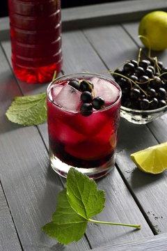 Cold lemonade with black currant, lime and ice cubes